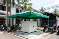 60 kVA generator installed behind a Malaysian shophouse row: silent diesel genset on a concrete pad